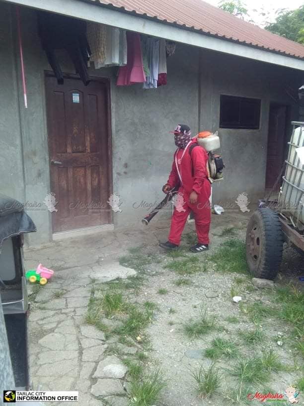 A government worker disinfects a residential area in Tarlac City