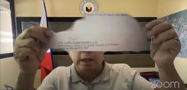 House committee on public accounts chairperson Rep. Jose Singson shows lawyer Christopher Lloyd Lao a copy of a letter which the latter signed as undersecretary of the Office of the Special Assistant to the President, amid his denial that he directly reported to now-Senator Bong Go.