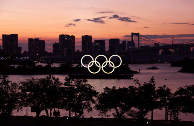 The Olympic Rings are seen in front of the skyline during sunset one night ahead of the official opening of the Tokyo 2020 Olympic Games in Tokyo, Japan