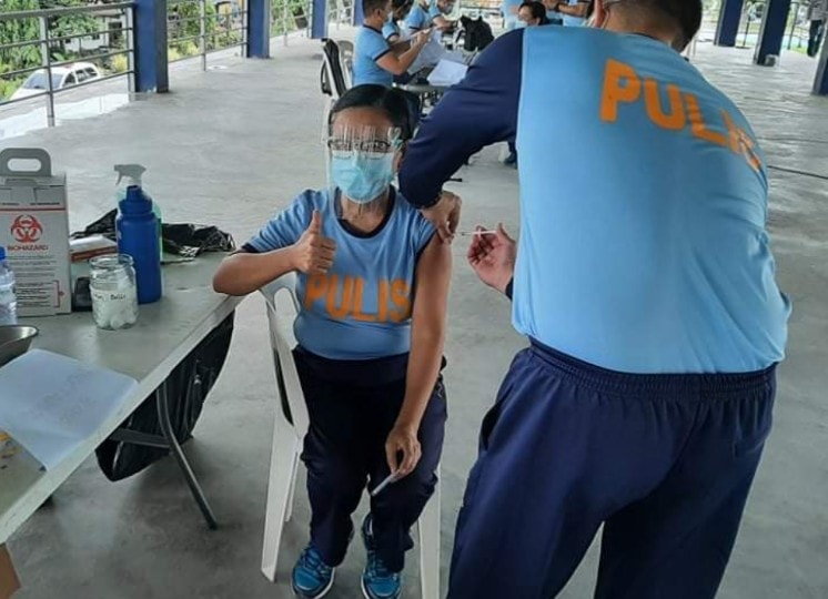 A police officer gets vaccinated against COVID-19 at Camp Julian Olivas in Pampanga