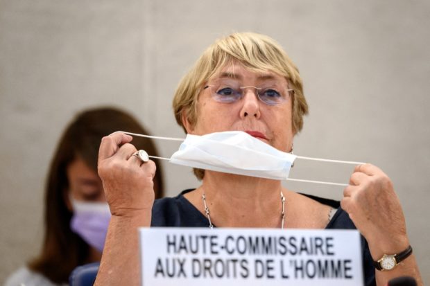 United Nations High Commissioner for Human Rights Michelle Bachelet removes her facemask as a preventive measure against the Covid-19 coronavirus prior to delivering a speech at the opening of a session of the UN Human Rights Council in Geneva, on September 13, 2021. - The UN rights chief warned that environmental threats from pollution and climate change were sparking and deepening conflicts worldwide, and will soon constitute the biggest challenge to human rights. (Photo by Fabrice COFFRINI / AFP)