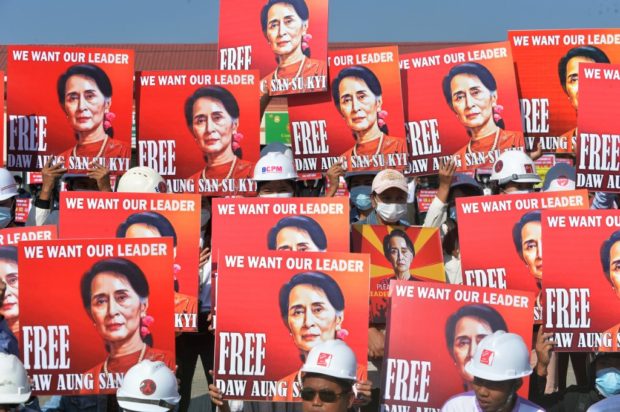 (FILES) In this file photo taken on February 15, 2021, a group of protesting engineers hold up signs calling for the release of detained Myanmar civilian leader Aung San Suu Kyi during a demonstration against the military coup in Naypyidaw. - Myanmar's junta will put ousted leader Aung San Suu Kyi on trial for corruption, her lawyer said on September 17, 2021, adding to a raft of ongoing cases that could see her jailed for decades. (Photo by STR / AFP)