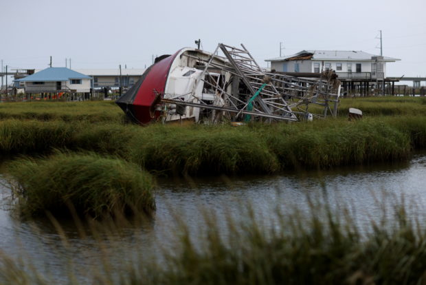 A boat damaged by hurricane Ida rests on its side in Leeville, Louisiana, U.S., September 2, 2021. REUTERS/Leah Millis