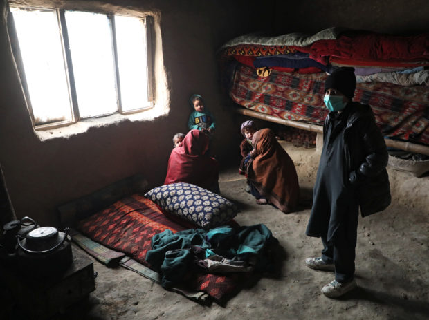 Internally displaced Afghan family sit at their shelter on the outskirts of Kabul