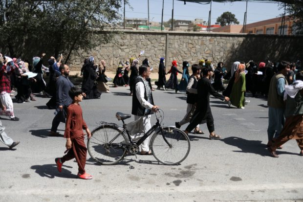 An Afghan man carries his bike as he walks with protesters during the anti-Pakistan protest in Kabul, Afghanistan, September 7, 2021. WANA (West Asia News Agency) via REUTERS