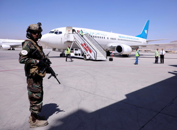 A member of Taliban forces stands guard next to a plane that has arrived from Kandahar at Hamid Karzai International Airport in Kabul, Afghanistan September 5, 2021. REUTERS/Stringer