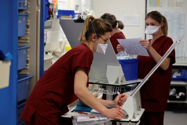 FILE PHOTO: Medical workers work in the Intensive Care Unit (ICU) where patients suffering from the coronavirus disease (COVID-19) are treated at Cambrai hospital, France, April 1, 2021.  REUTERS/Pascal Rossignol