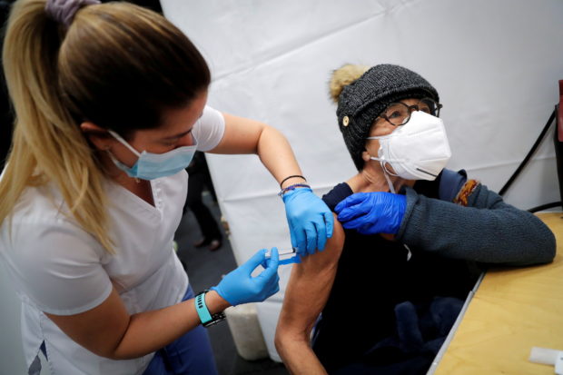 A healthcare worker administers a shot of the Moderna COVID-19 Vaccine to a woman at a pop-up vaccination site operated by SOMOS Community Care during the coronavirus disease (COVID-19) pandemic in Manhattan in New York City, New York, U.S.,