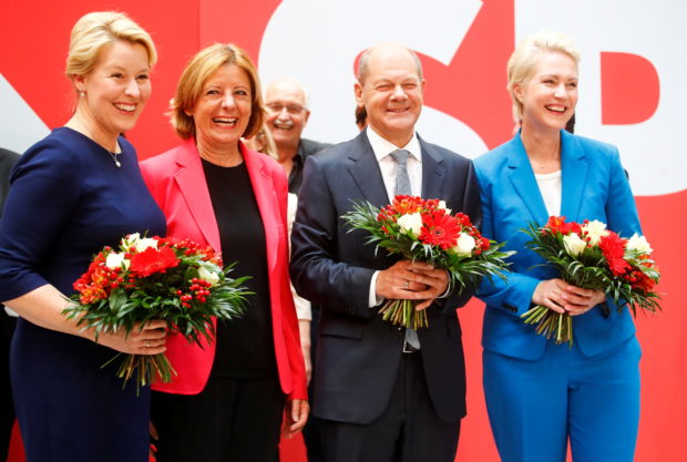 Social Democratic Party (SPD) leader and top candidate for chancellor Olaf Scholz, Mecklenburg-Western Pomerania state Prime Minister Manuela Schwesig, Rhineland-Palatinate State Premier Malu Dreyer and SPD member Franziska Giffey carry bouquets of flowers at their party leadership meeting, one day after the German general elections, in Berlin, Germany, September 27, 2021. REUTERS/Wolfgang Rattay