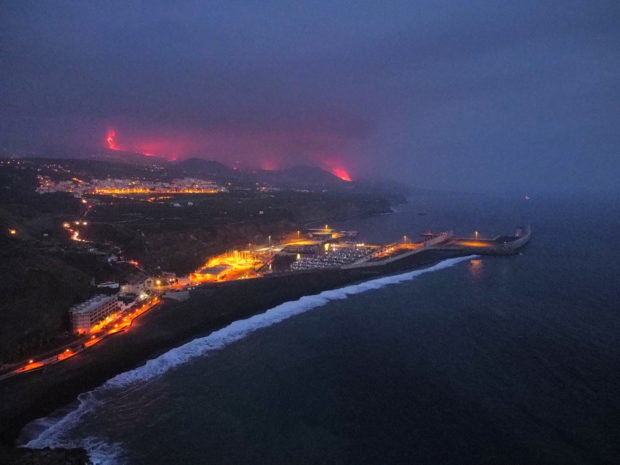 Lava is seen and smoke rises following the eruption of a volcano, in the Port of Tazacorte