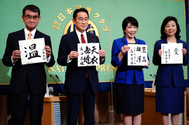 Candidates for the presidential election of the ruling Liberal Democratic Party pose with papers with their sign and words prior to a debate session held by Japan National Press Club