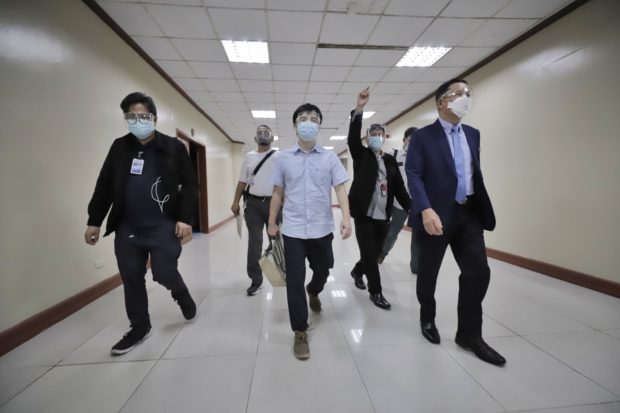 Members of the Office of the Sergeant-At-Arms escort Pharmally Pharmaceuticals Corporation Executive Linconn Ong inside the Senate building