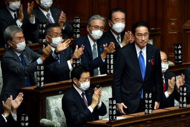 Leader of Japan's ruling Liberal Democratic Party (LDP) Fumio Kishida (2nd R) is applauded after being elected as new prime minister at the lower house of parliament in Tokyo on October 4, 2021 (Photo by Kazuhiro NOGI / AFP)
