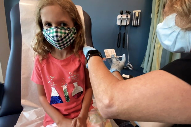 Lydia Melo, 7, is inoculated with one of two reduced 10 ug doses of the Pfizer BioNtech COVID-19 vaccine during a trial at Duke University in Durham, North Carolina September 28, 2021 in a still image from video. Video taken September 28, 2021. Shawn Rocco/Duke University/Handout via REUTERS