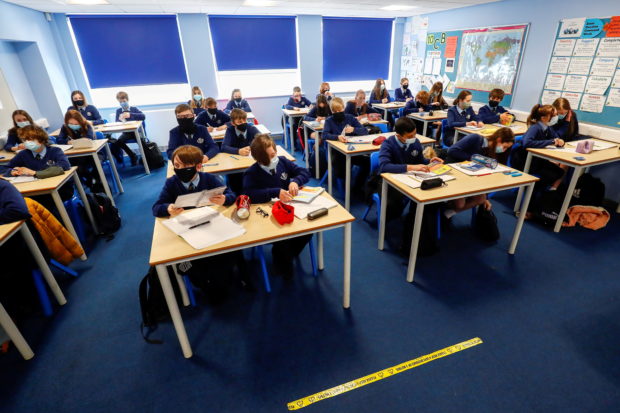 FILE PHOTO: Students attend a lesson at Weaverham High School, as the coronavirus disease (COVID-19) lockdown begins to ease, in Cheshire, Britain, March 9, 2021. REUTERS/Jason Cairnduff/File Photo
