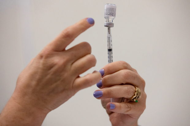 A nurses fills up syringes for patients as they receive their coronavirus disease (COVID-19) booster vaccination during a Pfizer-BioNTech vaccination clinic in Southfield, Michigan, U.S., September 29, 2021.  REUTERS/Emily Elconin