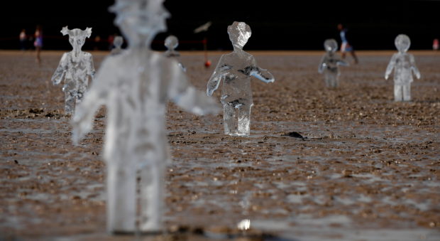 Ice sculptures of children created by Sand in Your Eye to highlight the importance of COP26, the global climate conference, are seen at New Brighton Beach on the Wirral peninsular in New Brighton, Britain May 31, 2021. REUTERS/Jason Cairnduff/File Photo