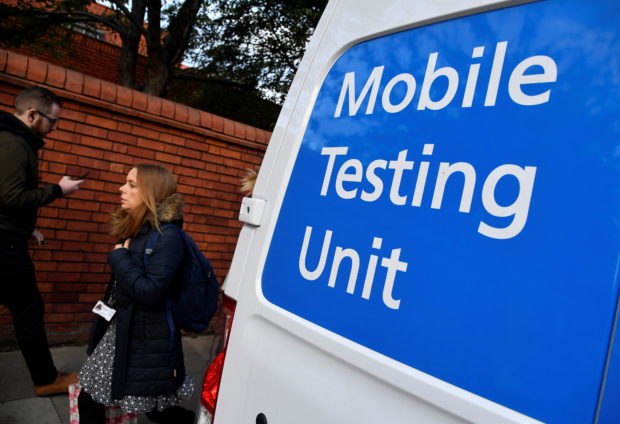 People walk past a COVID-19 Mobile Testing Unit van, amidst the spread of the coronavirus disease (COVID-19), in London, Britain, October 21, 2021. REUTERS/Toby Melville