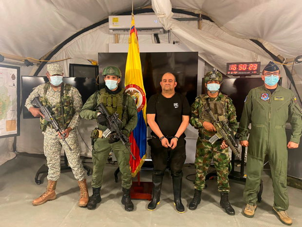 Dairo Antonio Usuga David, alias "Otoniel", top leader of the Gulf clan, poses for a photo escorted by Colombian military soldiers after being captured, in Necocli, Colombia October 23, 2021. Colombia's Military Forces/Handout via REUTERS