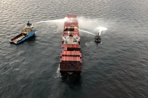 Tugboats pour water on the container ship Zim Kingston after it caught fire the day before off the coast of Victoria, British Columbia, Canada October 24, 2021.  Canadian Coast Guard/Handout via REUTERS
