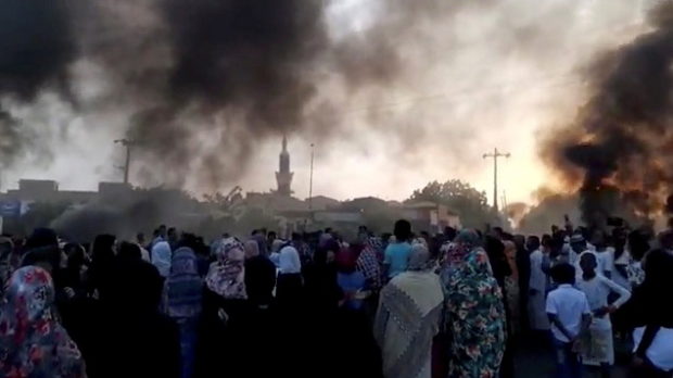 People gather on the streets as smoke rises in Kartoum, Sudan, amid reports of a coup, October 25, 2021, in this still image from video obtained via social media. RASD SUDAN NETWORK via REUTERS
