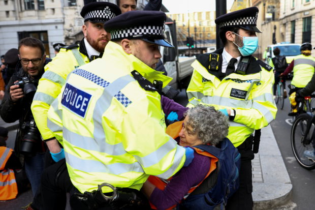 Police officers carry an Insulate Britain activist during a protest in London, Britain October 25, 2021. REUTERS/Henry Nicholls