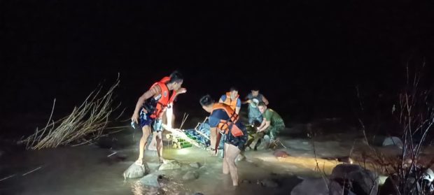Rescuers from the Suyo police station in Ilocos Sur recover the body of a girl swept away Oct. 11 by floods due to Storm "Maring."