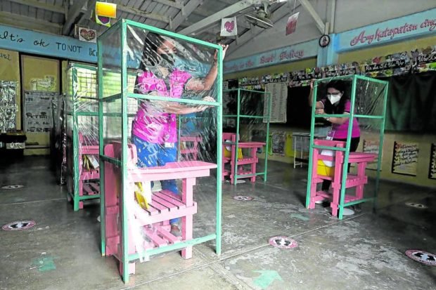 SAFETY FIRST IN CLASS Teachers Lynell Corbito and Aida Conchada prepare a classroom for the resumption of in-person classes in Tamulaya Elementary School in Polilio Island, Quezon province. —RICHARD A. REYES