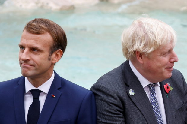 Britain's Prime Minister Boris Johnson and French President Emmanuel Macron look on in front of the Trevi Fountain during the G20 summit in Rome, Italy, October 31, 2021. REUTERS/Guglielmo Mangiapane