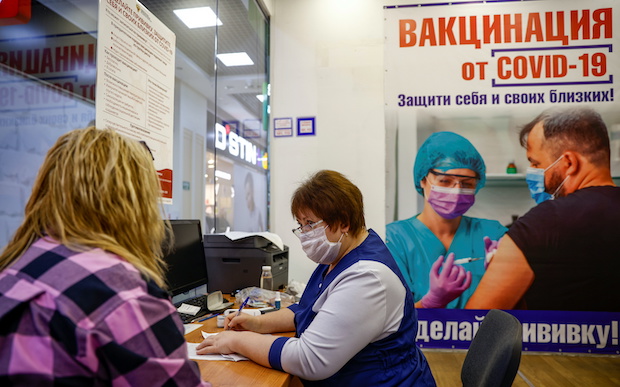 A medical worker registers documents of a patient at a vaccination centre in Oryol