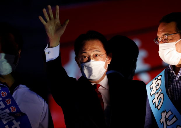 Japan's Prime Minister Fumio Kishida, who is also the President of the ruling Liberal Democratic Party, waves to voters from atop the campaigning bus on the last day of campaigning for the October 31 lower house election, amid the coronavirus disease (COVID-19) pandemic, in Tokyo, Japan October 30, 2021. REUTERS/Issei Kato
