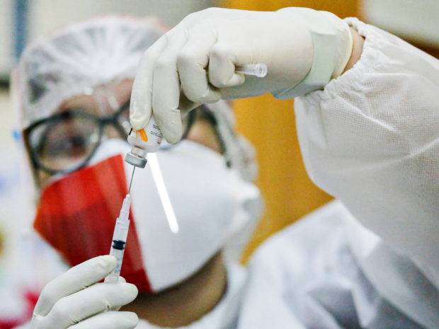 FILE PHOTO: A healthcare worker wearing an Indonesian flag mask to mark the country's 76th Independence Day, prepares a dose of China's Sinovac Biotech vaccine against the coronavirus disease (COVID-19) during a mass vaccination program in Jakarta, Indonesia, August 17, 2021. REUTERS/Ajeng Dinar Ulfiana