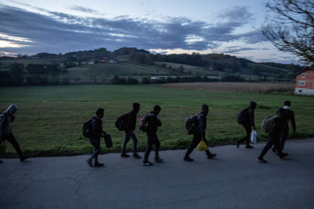 FILE PHOTO: Migrants walk towards the Bosnia-Croatia border in attempt to cross it what they call "the game", near Velika Kladusa, September 29, 2020. REUTERS/Marko Djurica/File Photo