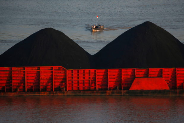 A man stands on a boat as coal barges queue to be pulled along Mahakam river in Samarinda, East Kalimantan province, Indonesia, August 31, 2019. Picture taken August 31, 2019. REUTERS/Willy Kurniawan