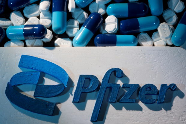 FILE PHOTO: A 3D printed Pfizer logo is placed near medicines from the same manufacturer in this illustration taken September 29, 2021. REUTERS/Dado Ruvic