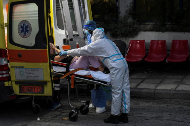 FILE PHOTO: Medical workers wearing personal protective equipment carry a patient on a stretcher, as she arrives on an ambulance at the coronavirus disease (COVID-19) ward of the Ippokrateio General Hospital in Thessaloniki, Greece, November 3, 2021. REUTERS/Alexandros Avramidis/File Photo