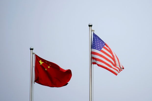 FILE PHOTO: Chinese and U.S. flags flutter outside a company building in Shanghai, China April 14, 2021. REUTERS/Aly Song//File Photo