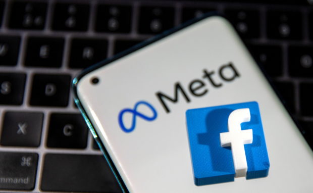 FILE PHOTO: A smartphone with Meta logo and a 3D printed Facebook logo is placed on a laptop keyboard in this illustration taken October 28, 2021.  STORY: Meta: Technical glitch triggered ‘automated blocking’ of sites