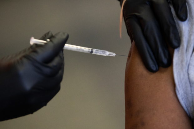 FILE PHOTO: A patient receives their coronavirus disease (COVID-19) vaccine booster during a Pfizer-BioNTech vaccination clinic in Southfield, Michigan, U.S., September 29, 2021. REUTERS/Emily Elconin
