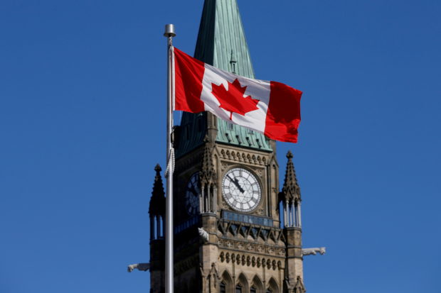 FILE PHOTO: A Canadian flag flies in front of the Peace Tower on Parliament Hill in Ottawa, Ontario, Canada, March 22, 2017. REUTERS/Chris Wattie