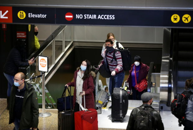 People enter the baggage claim area from the international arrivals terminal as the U.S. reopens air and land borders to coronavirus disease (COVID-19) vaccinated travellers for the first time since the COVID-19 restrictions were imposed, at Sea-Tac Airport in Seattle, Washington, U.S. November 8, 2021. REUTERS/Lindsey Wasson