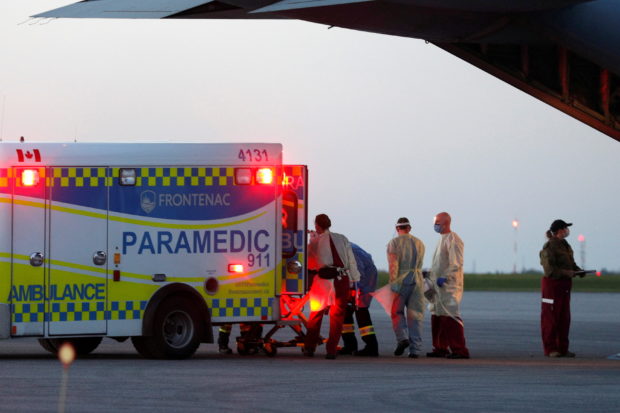 Medical personnel unload a patient from a Royal Canadian Air Force CC-130J Hercules transport aircraft which departed from Saskatoon, after the province of Saskatchewan said it would be sending patients with the coronavirus disease (COVID-19) from overloaded ICU wards to Ontario hospitals, in Kingston, Ontario, Canada October 28, 2021.  REUTERS/Lars Hagberg