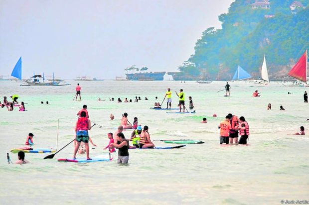OFF TO THE BEACH Tourists on Boracay Island flock to its famous main beach on Nov. 4 as restrictions are loosened. Fully vaccinated travelers are no longer required to submit a negative swab test result when entering the island starting on Nov. 16. —JACK JARILLA