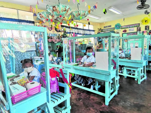earners of Napo Elementary School in Barangay Napo, Linamon, Lanao del Norte are separated with makeshift cubicles as face-to-face classes start.