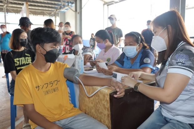 Photo of barangay health workers giving COVID-19 vaccines to children in Zambales for story: More benefits, perks for barangay health workers pushed