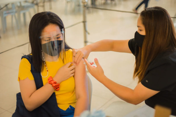 A student of the City College of San Fernando in Pampanga province gets vaccinated against COVID-19