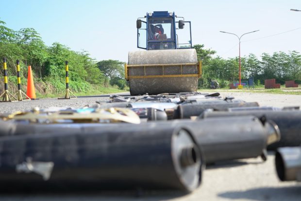 A compactor destroys these confiscated mufflers in Tuguegarao City