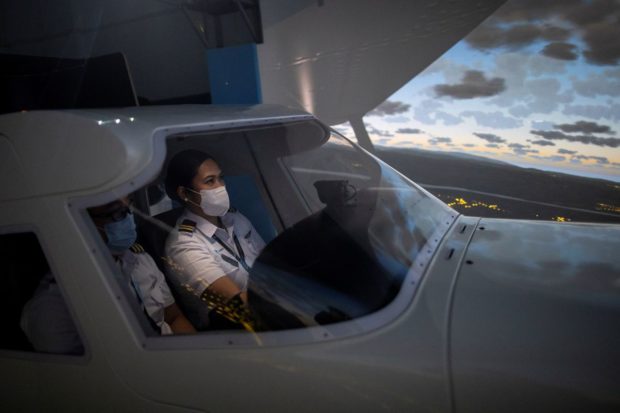 Cadet Casey Abadilla, a flight student, operates a flight simulator while wearing a mask for protection against the coronavirus disease (COVID-19), at the Alpha Aviation Group campus in Clark, Pampanga province, Philippines, November 3, 2021. Picture taken November 3, 2021. REUTERS/Eloisa Lopez