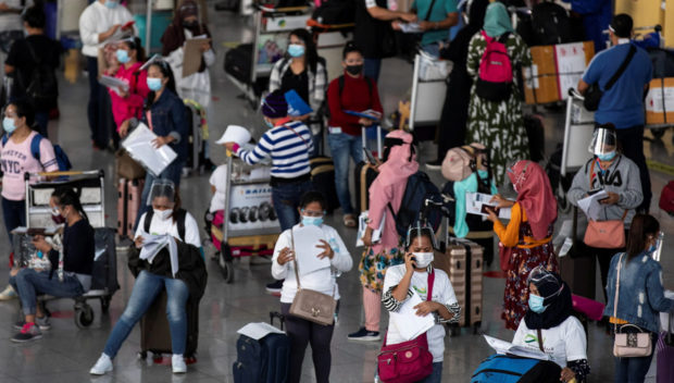 FILE PHOTO: Passengers, mostly Overseas Filipino Workers (OFW) queue at the departure area of Ninoy Aquino International Airport amid the coronavirus disease (COVID-19) outbreak, in Pasay, Metro Manila, Philippines, June 1, 2021. REUTERS/Eloisa Lopez