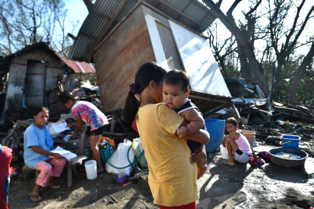 Residents gather next to their destroyed house in Carcar, Philippines' Cebu province on December 18, 2021, days after Super Typhoon Rai hit the city. (Photo by VICTOR KINTANAR / AFP)